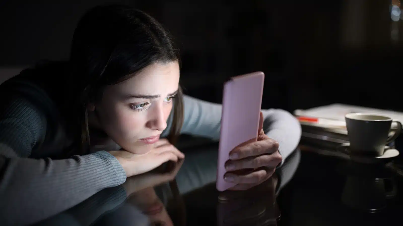 Social Media und psychische Probleme - Ein Mädchen schaut traurig in das Smartphone